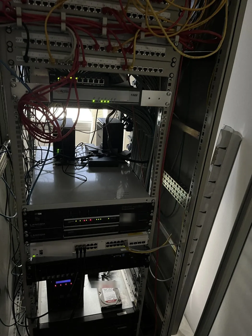 Serverschrank Vorderseite vorher: ungeordnete Patchkabel, Server und Router